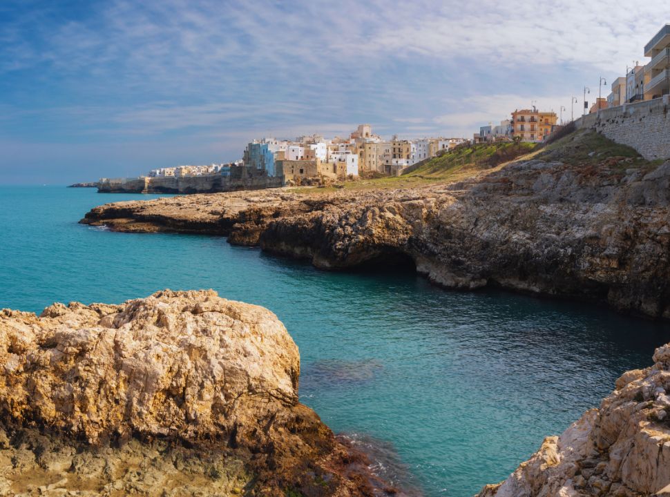 view of polignano a mare town set along the cliffs, crystal celar water invites you to take a jump