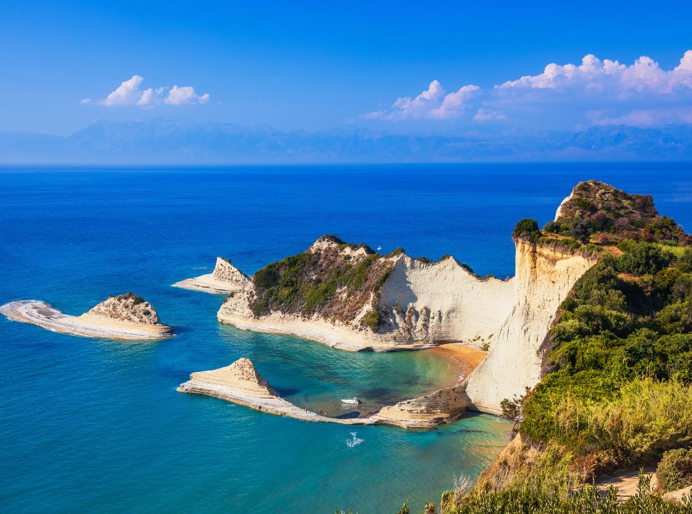 view of cape drastis cliff in clear ocean water in corfu greece