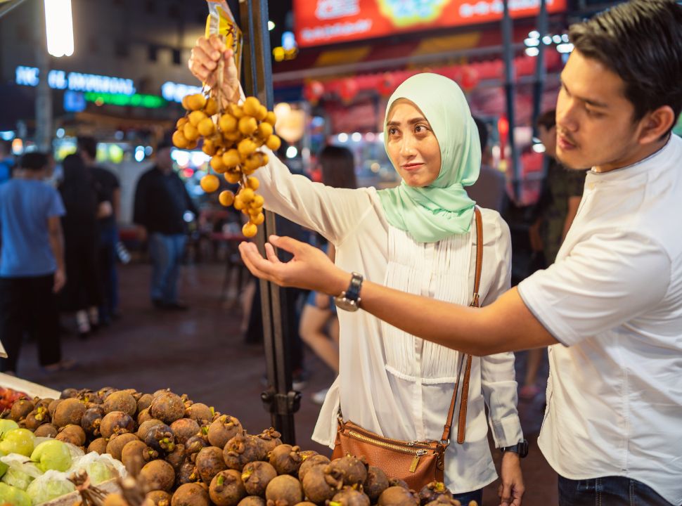 Malaysian couple buying fruits at a stall in Kuala Lumpur market