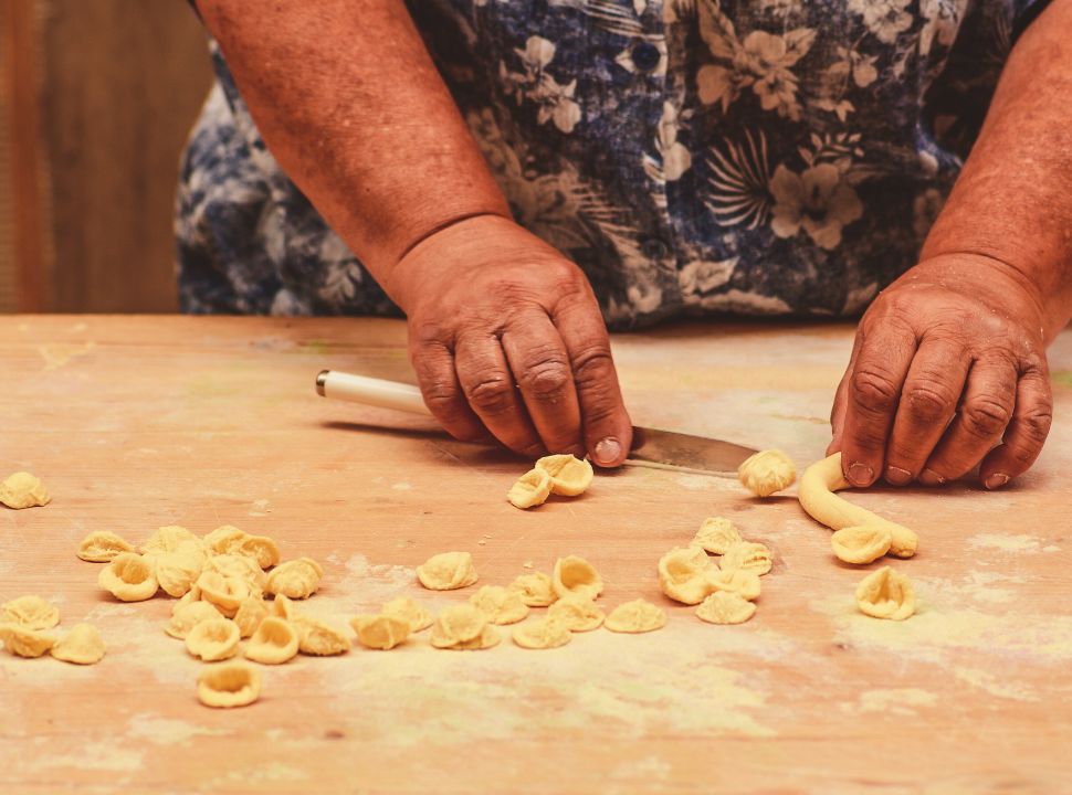 woman making fresh pasta known as orecchiette, a local puglian pasta