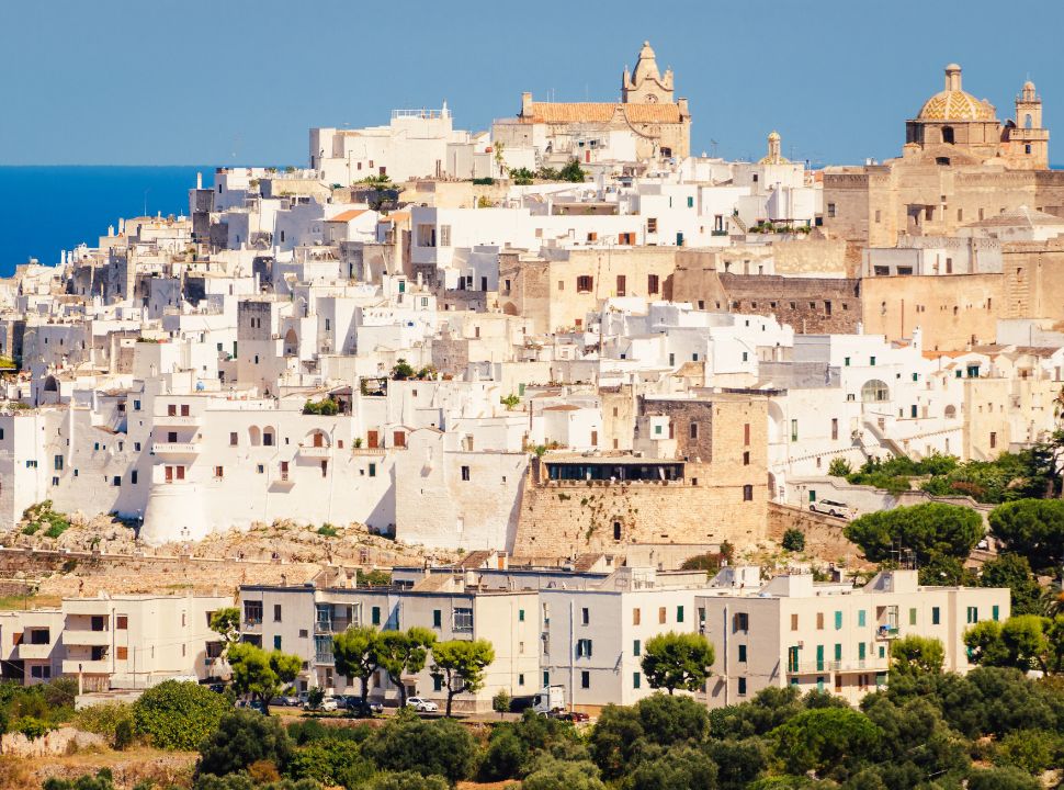 old town located on a hill surrounded by olive groves. This town in Puglia is famous for its white buildings and narrow streets. 