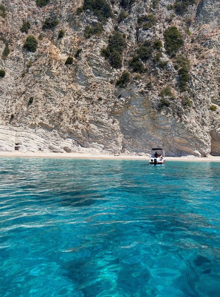 small rental boat anchored at a deserted beach in west corfu