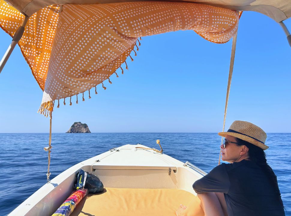 woman enjoying the view from a little boat at paleokastritsa corfu island greece