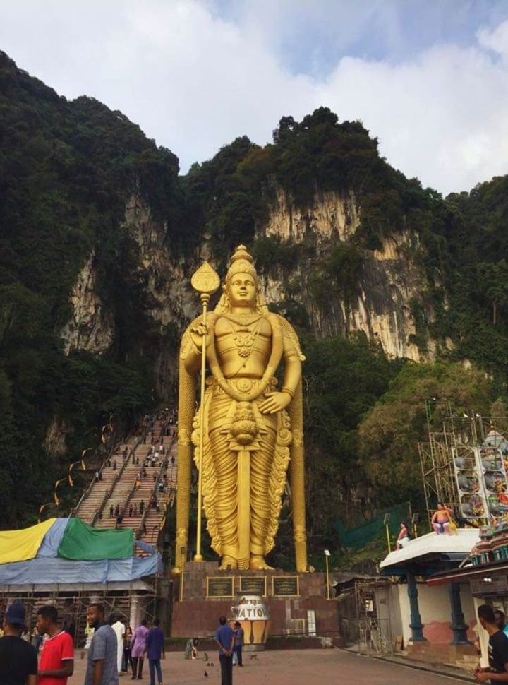 large golden statue in front of steep stairs leading to the batu caves near Kuala Lumpur Malaysia