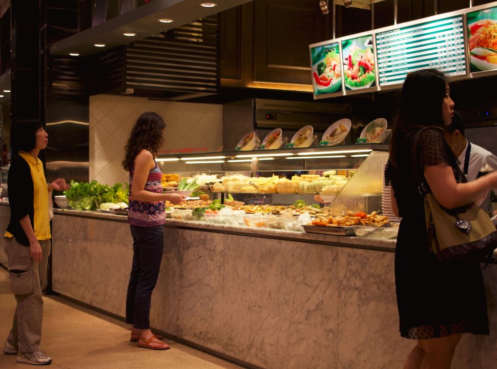 woman selecting vegetables at a food court in kuala lumpur