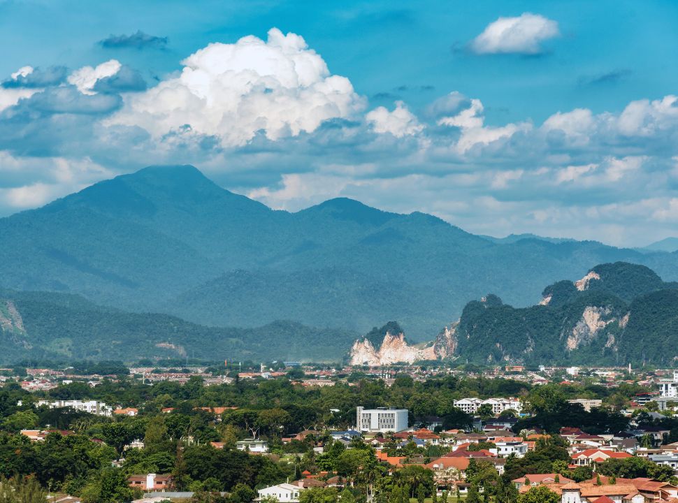 city surrounded by lush green mountains in malaysia