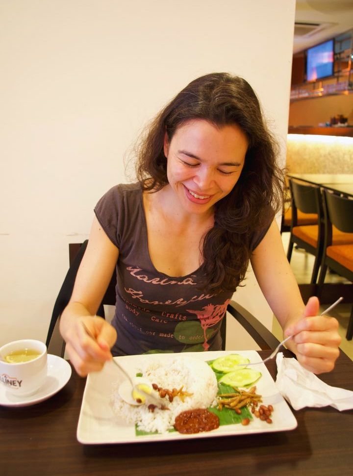 woman enjoying nasi lemak in a resturant in kuala lumpur malaysia