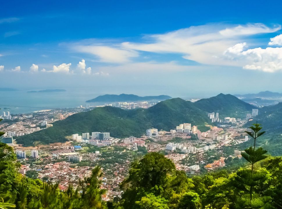 view of a city with beautiful mountains and ocean in the back in penang malaysia