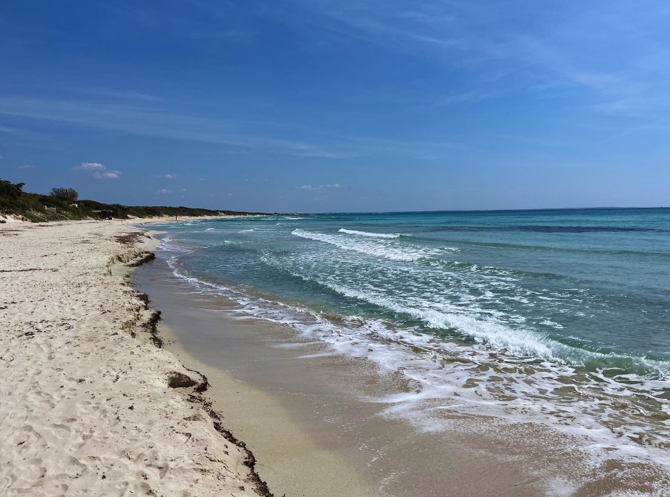 deserted soft sanded beach with clear blue water in Puglia Italy