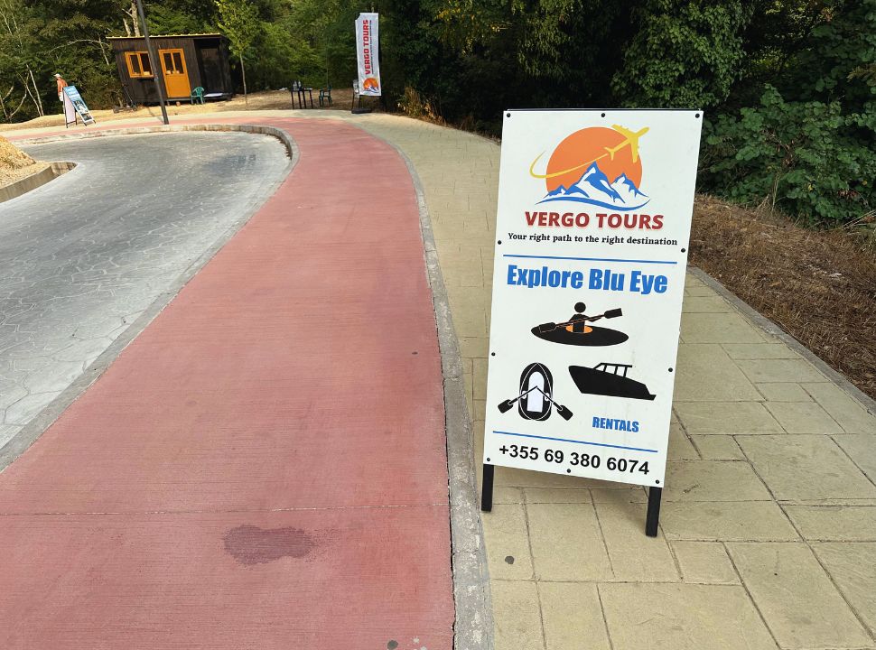 sign along the paved walkway at offering boat and kayak rentals at blue eye albania