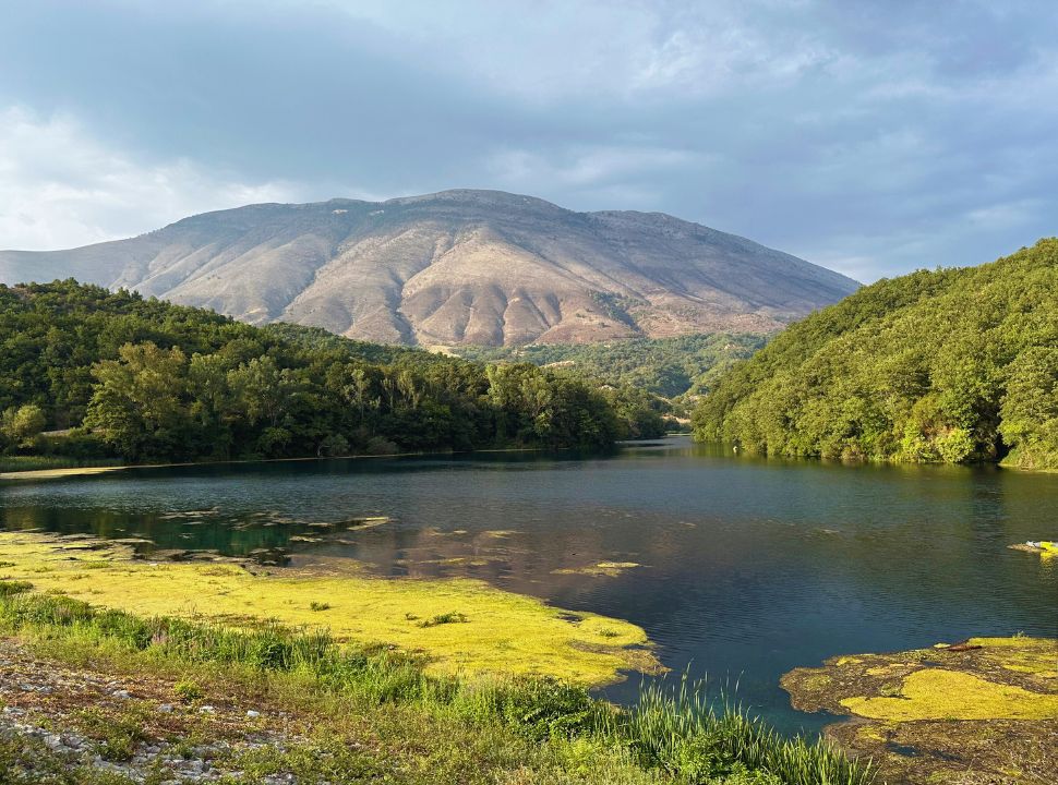 view of lake with a stunning mountain in the background at national park blue eye Albania