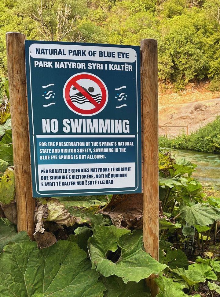 no swimming sign along the river at the blue eye in Albania