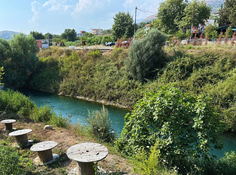 emerald green river flowing along the street at a village in Albania