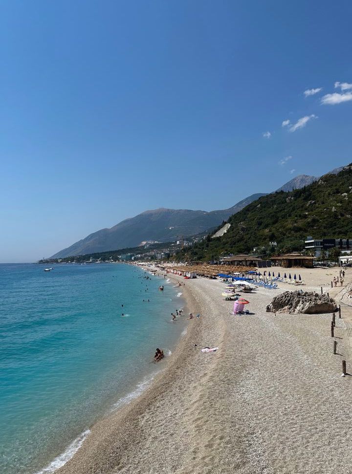 view of the long stretched Dhermi beach with mountain backdrop in the northern part of Albanian riviera