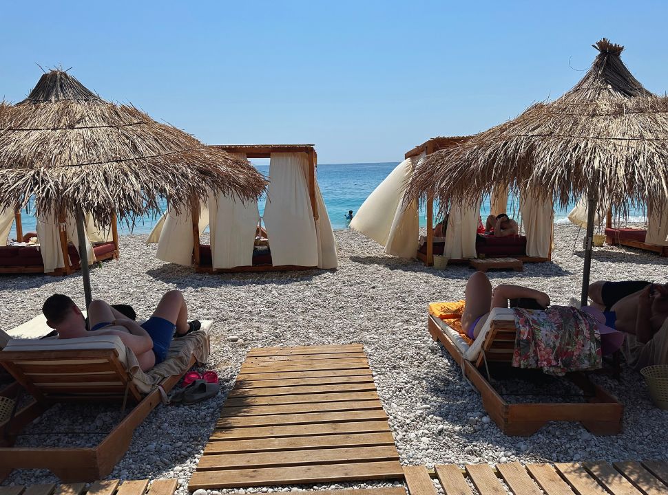 sun loungers and gazebo's at the waterfront at a beach club in Dhermi beach Albania