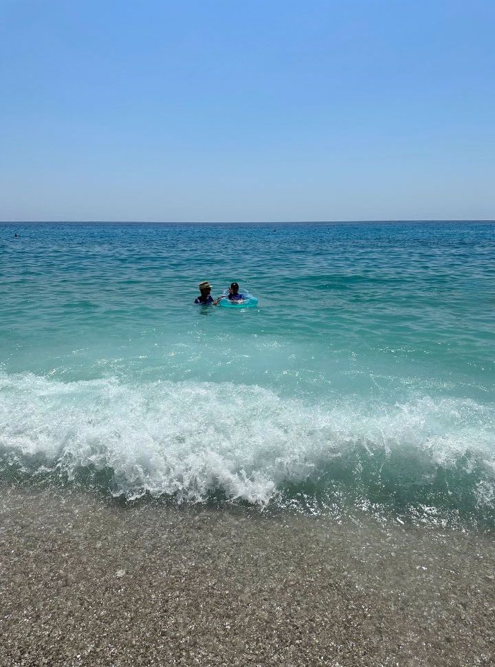 father and son swimming in the blue ocean water in Albania 