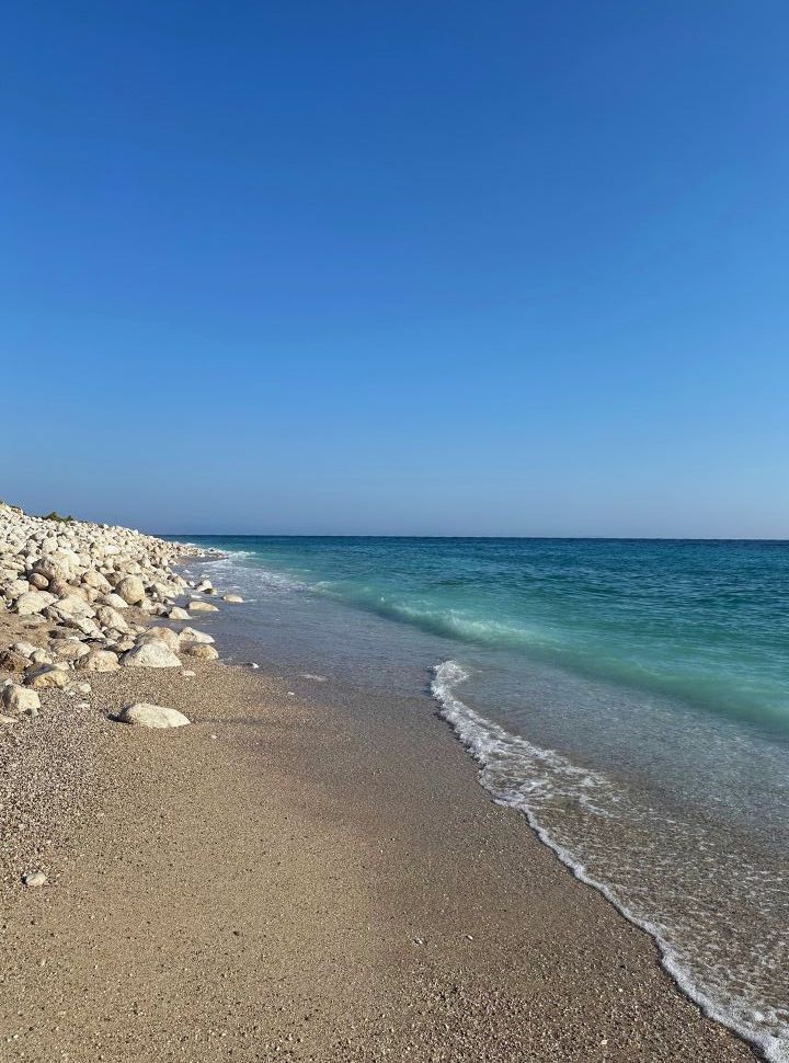 quiet patch of beach with big white bolders at a clear blue turquoise Ionian Sea Albania 