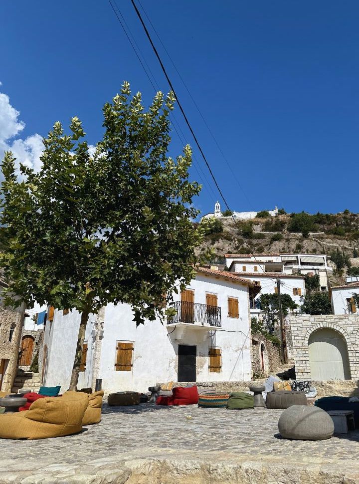 small square in old town Dhermi with the Monastery of St Mary visible on the top of the hill