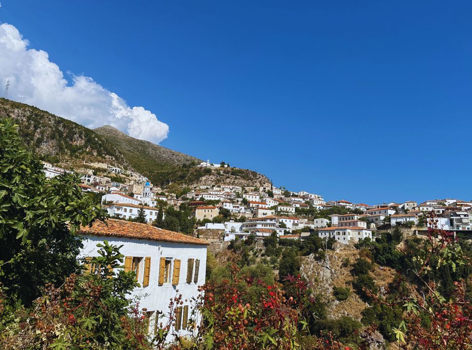 view of old town Dhermi lcoated on the mountain slopes, in the far distance a monastery is visible