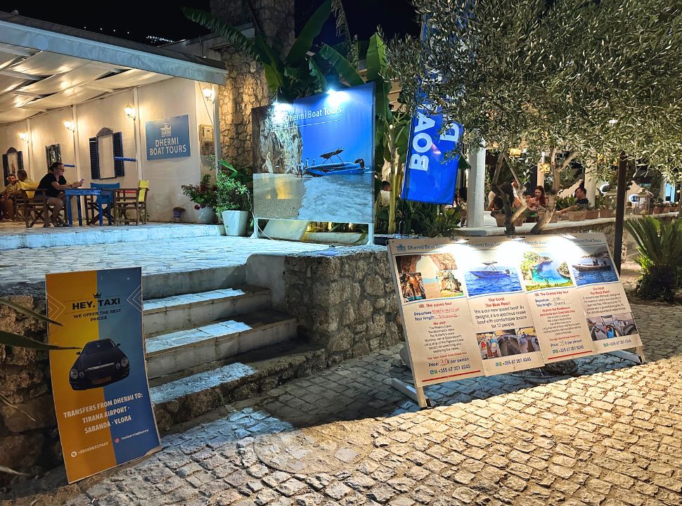 Dhermi boats tours office promoting their tours and taxi service at Dhermi Albania