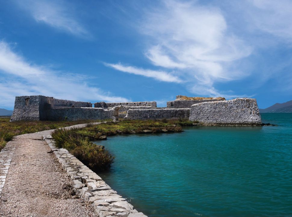 ruins of a fortress set along the water at butrint