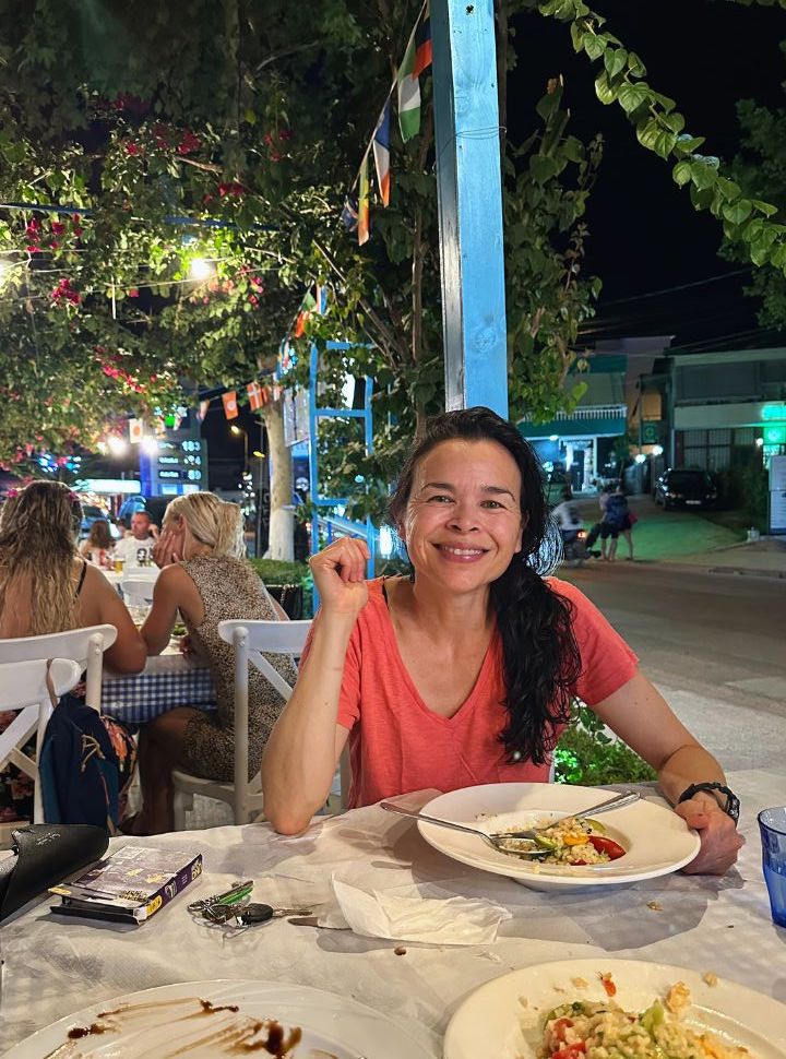 woman having dinner at a open air restaurant along the main street of Ksamil