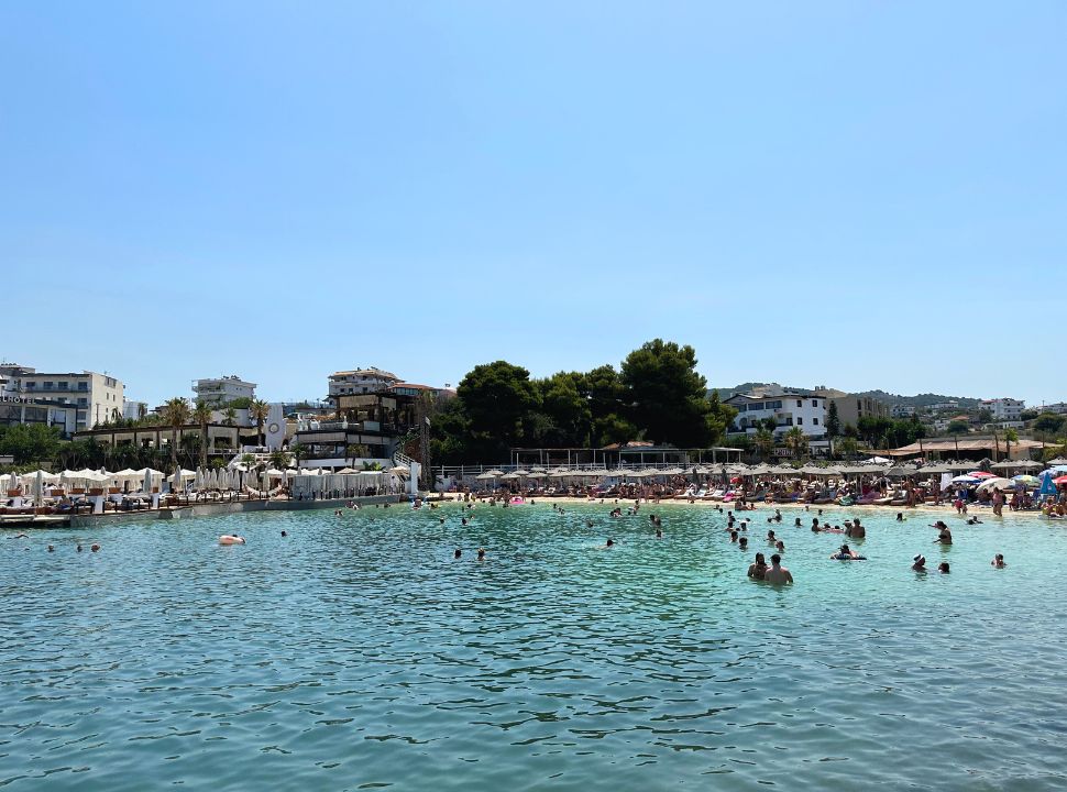 view of paradise beach Ksamil, full with sun beds, a lot of people are enjoying the turquoise water