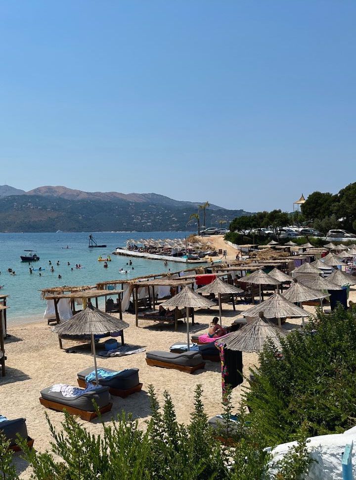 beach with beautiful blue water, overcrowded with sun loungers in Albania