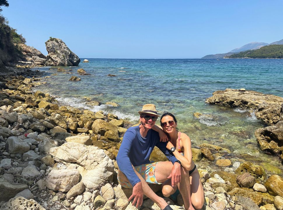 couple man and woman posing at a rocky beach along the ocean water in Albania