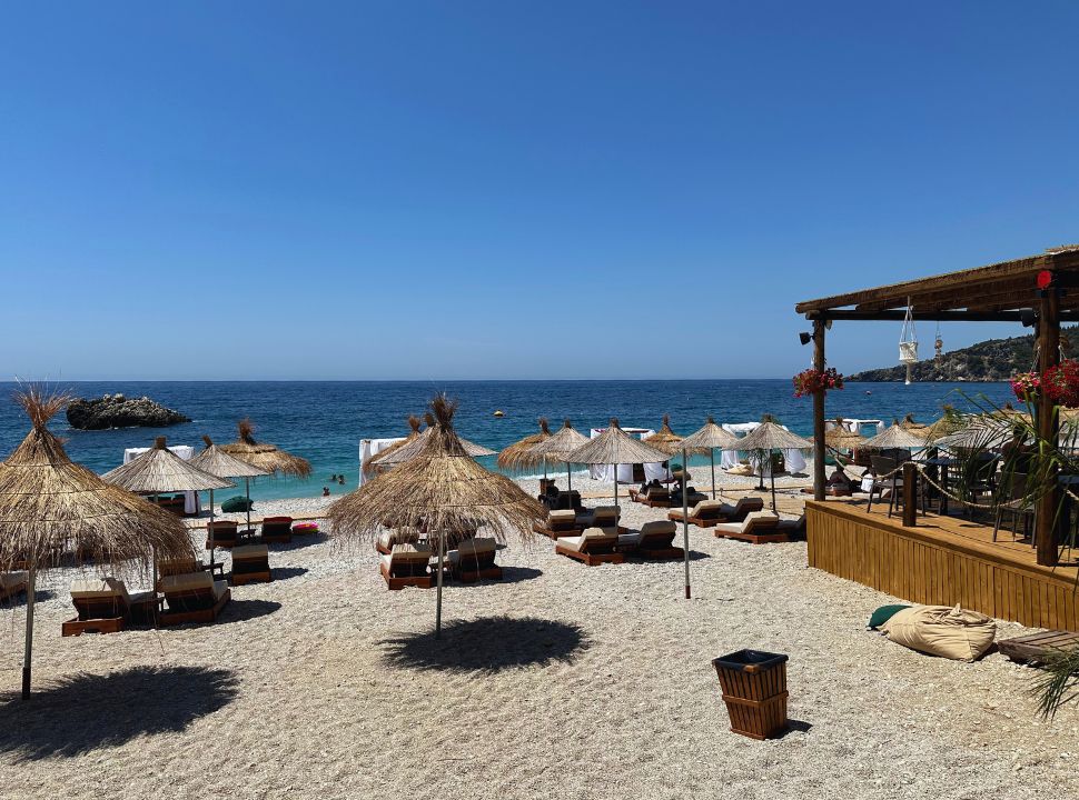 empty beach restaurant with sun loungers and gazebos at Livadhi beach Albania