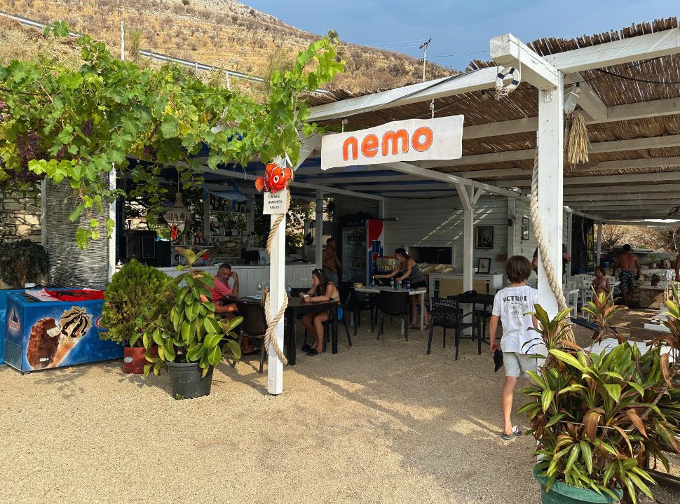 beach restaurant with thatched roof, welcoming atmosphere at Porto Palermo Beach Albanian Riviera