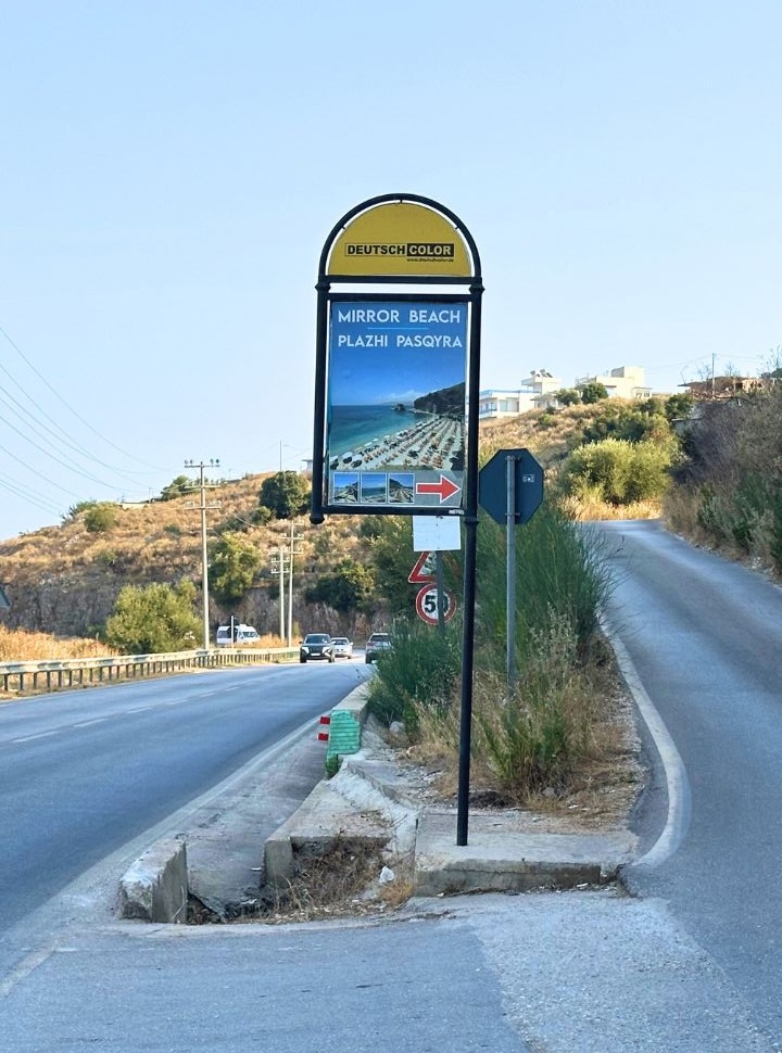 sign along the main road indicating where to get off to get to Pasqyra Beach Albania