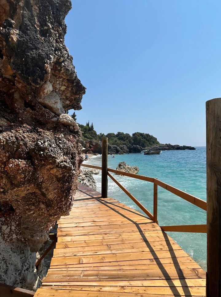 wooden walkway along the rocky cliffs leading to beautiful beach at Dhermi Albania