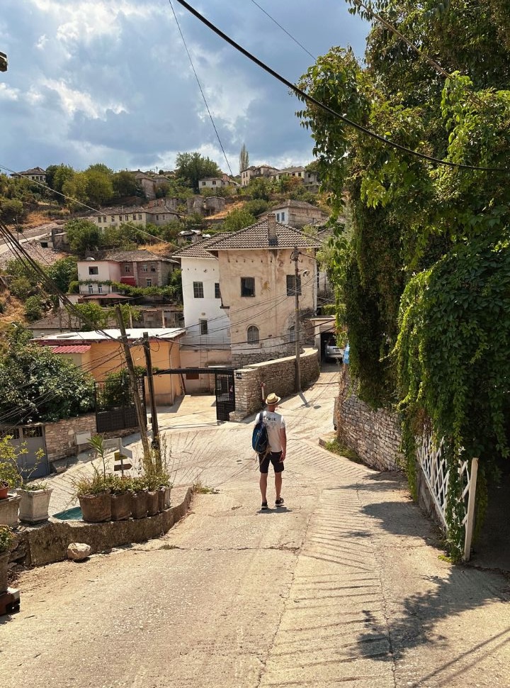 man walking down one of the many steep streets in Gjirokaster Albania