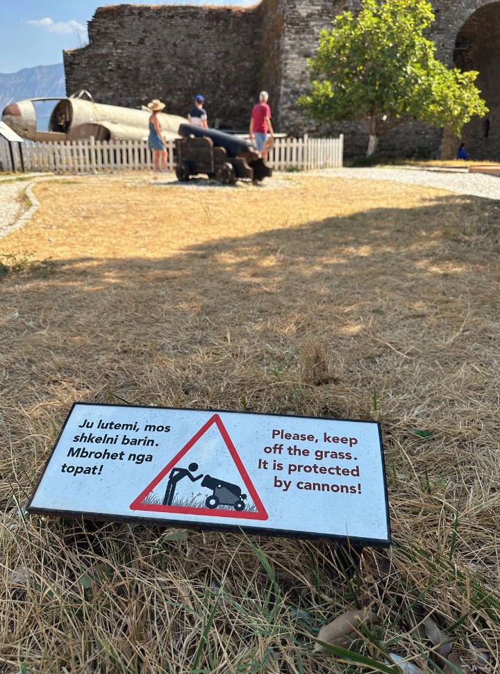 a sign in the grass at the castle of Gjirokaster stating: please keep off the grass. It is protected by canons