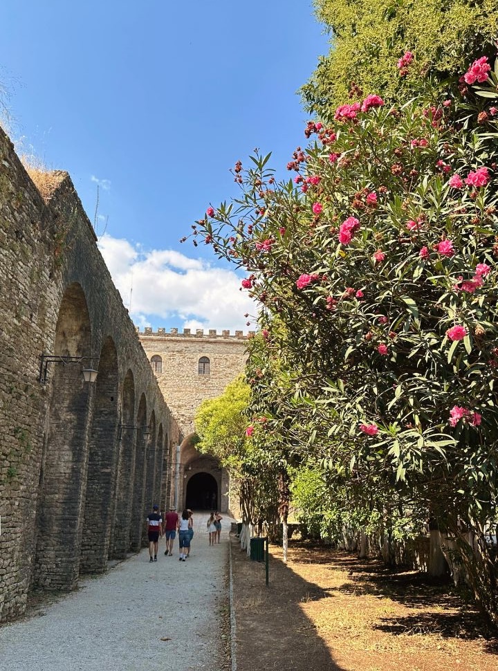 the courtyard of the Gjirokastër castle with a pink flowered tree