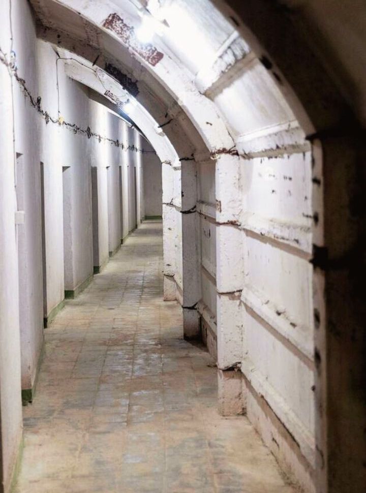 narrow tunnel with doors on the left leading to rooms at the cold war museum in Gjirokaster