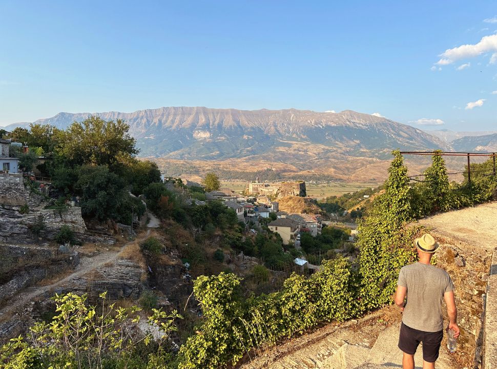 man looking at the view of the castle of Gjirokastër and the mountains