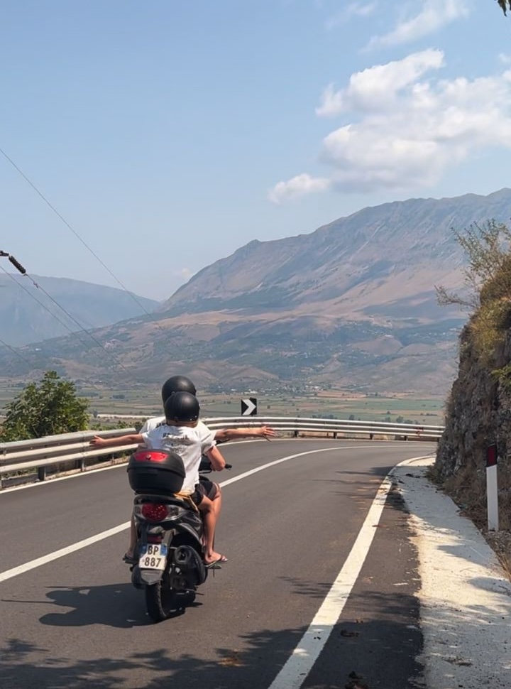 father and son driving on main road to Gjirokaster, good condition