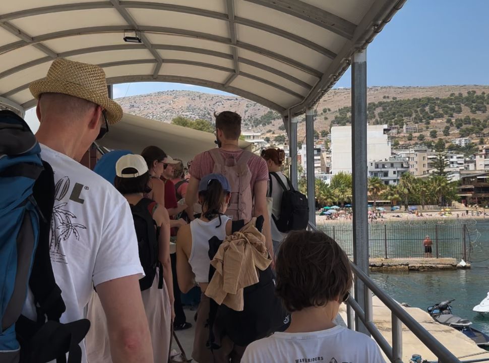 people standing in line outside waiting for passport check at Saranda Port Albania