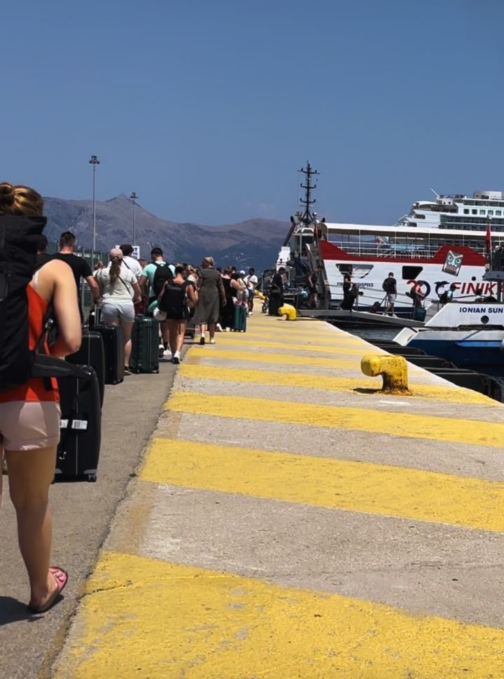 people queuing along the dock to board the ferry from corfu to Albania