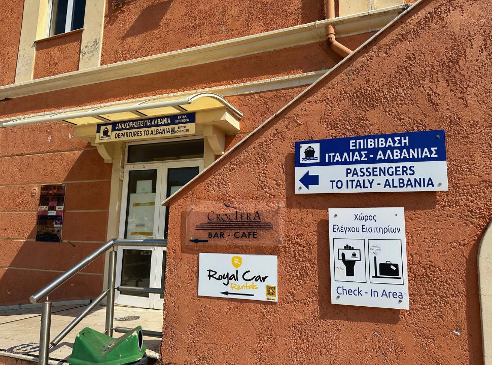 signs pointing passengers for Italy and Albani to the correct direction, departures and check in area