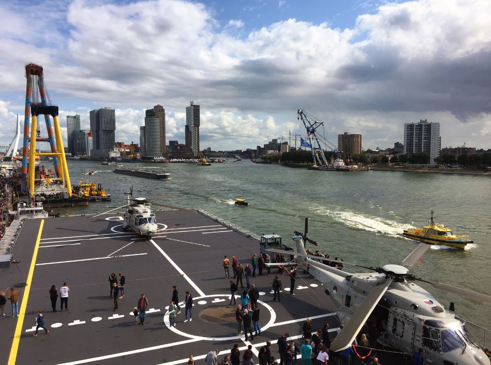 view over the platform of a ship with helicopters, boats are passing along the river Maas in Rotterdam