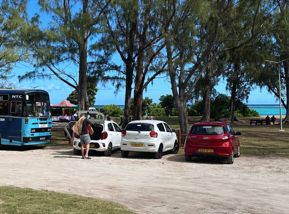 three small cars parked at the public parking area at the beach in Mauritius