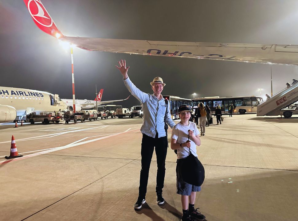 Father and son standing on a airport platform near the airplane during transit with the bus to the terminal at Istanbul Airport