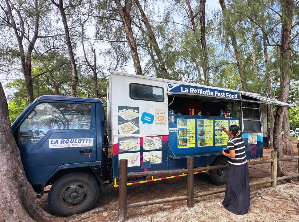 woman paying for her food at a food truck at Mont Choisy beach