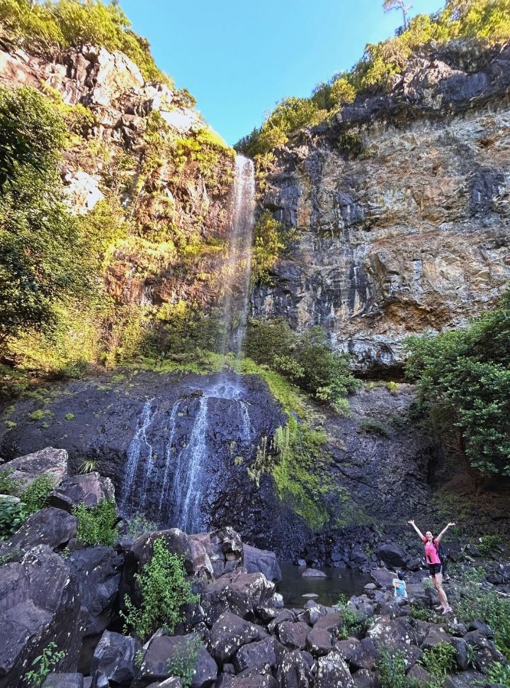 woman happy to arrive at a beautiful waterfall in Mauritius