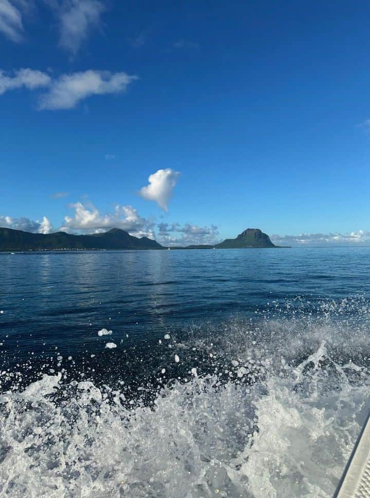 boat on the water with in the distance the island of Mauritius