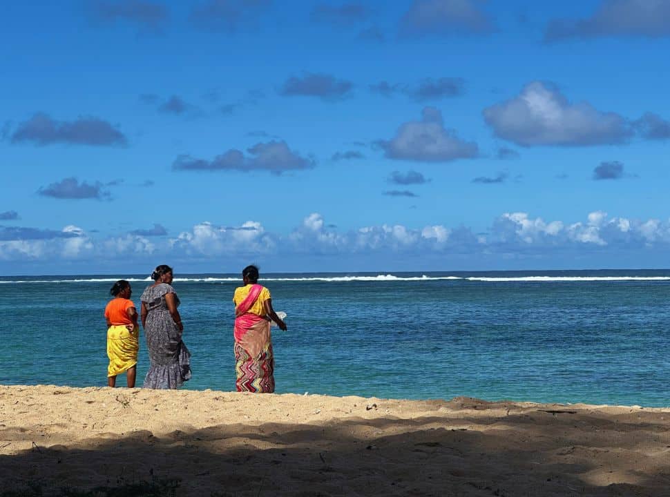 three women standing on the edge of the water at the public beach St Felix Mauritius