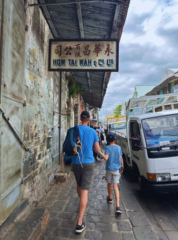 father and son walking along the street in an old part of town in port louis. Mauritius travel tips pack less then you usually do. 